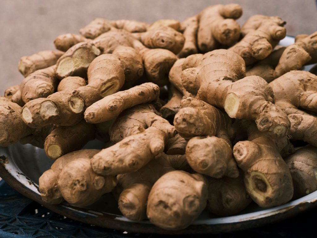 Close-up of fresh ginger roots in a bowl, highlighting its organic texture and earthy color.