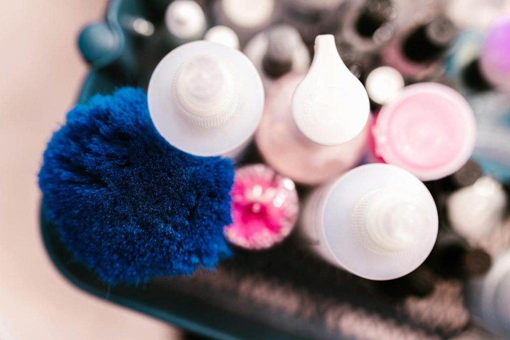 Colorful assortment of brushes and cosmetic containers viewed from above for beauty and skincare routines.