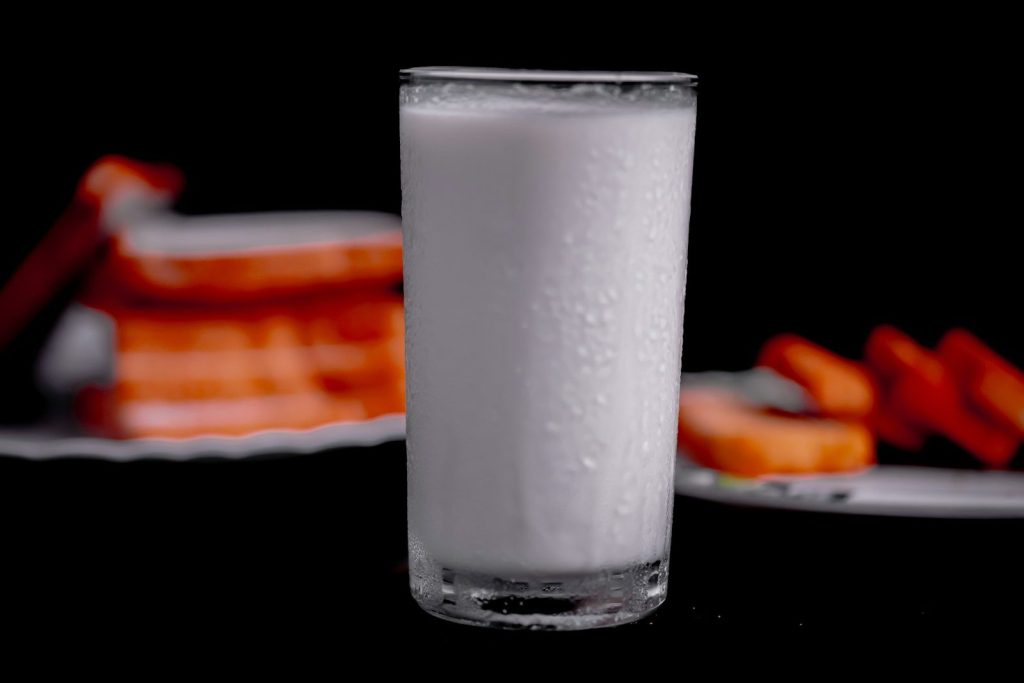 a glass of milk sitting on top of a table
