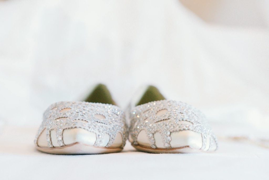 Close-up of sparkling silver decorative ballet flats on an elegant white background.