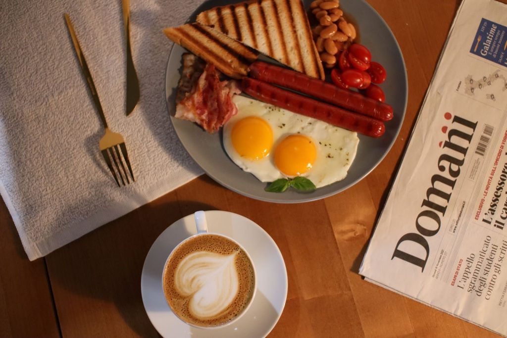 Flat lay of breakfast with eggs, coffee, and a newspaper offering a perfect morning vibe.