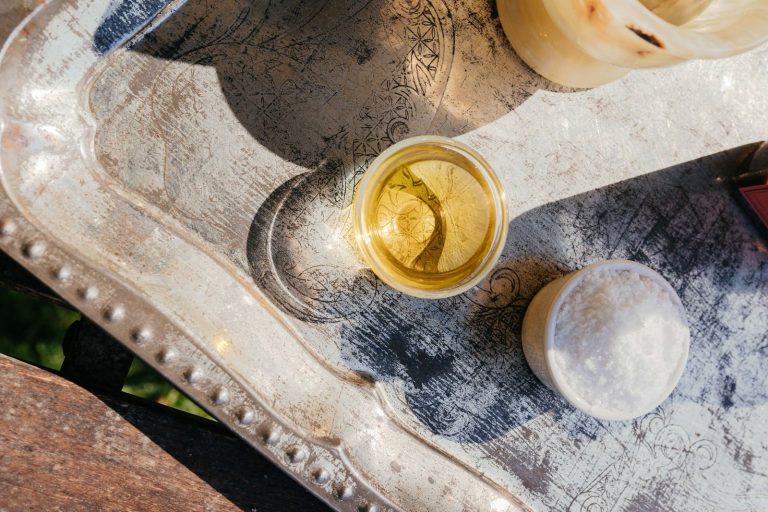 A close-up, top-view of cooking ingredients including oil and salt on a rustic silver tray.