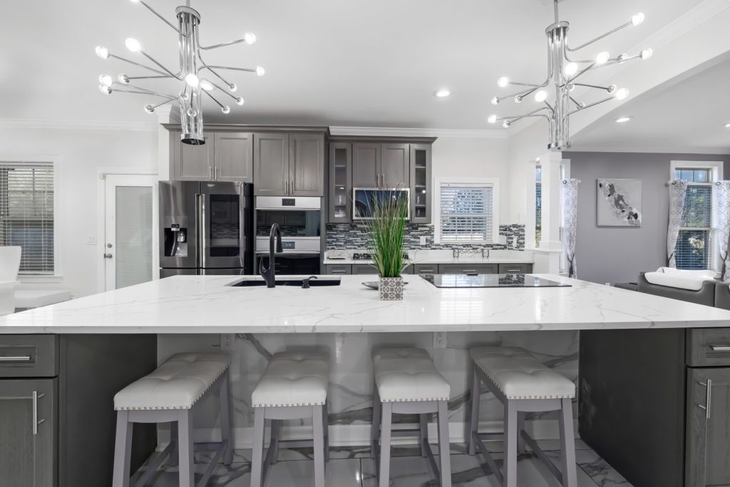 Spacious modern kitchen featuring marble countertops, contemporary design, and sleek appliances.