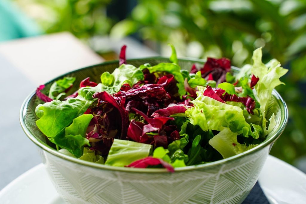 A colorful, leafy greens salad in a patterned bowl. Perfect for healthy eating inspiration.