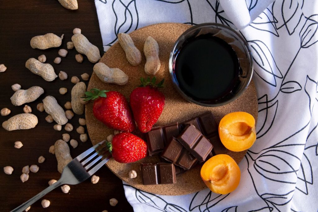 A delicious gourmet platter featuring strawberries, apricots, chocolate, and nuts.
