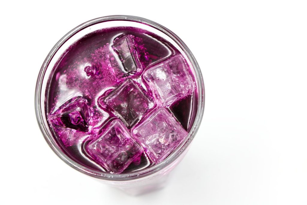 Top-down shot of a refreshing purple drink filled with ice cubes, perfect for a cooling refreshment.