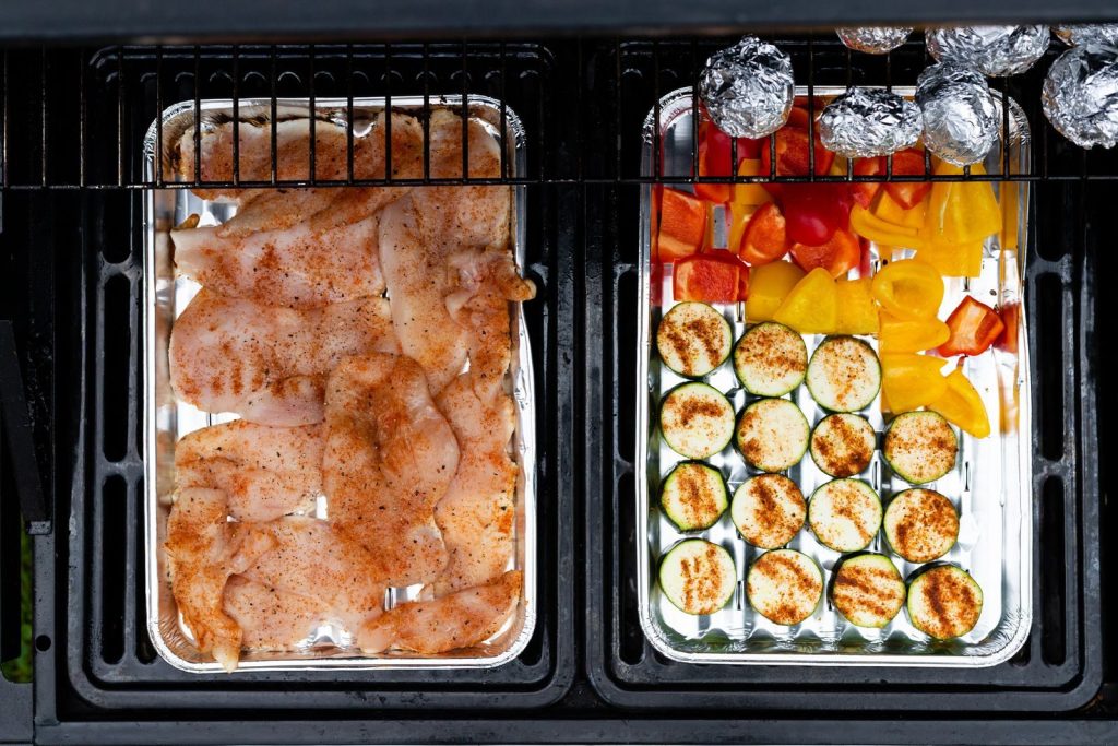 Top view of grilled chicken and vegetables on a barbecue grill, perfect for cooking inspiration.