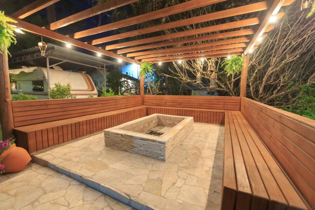 Inviting outdoor patio with wooden benches and fire pit, perfect for evening relaxation.