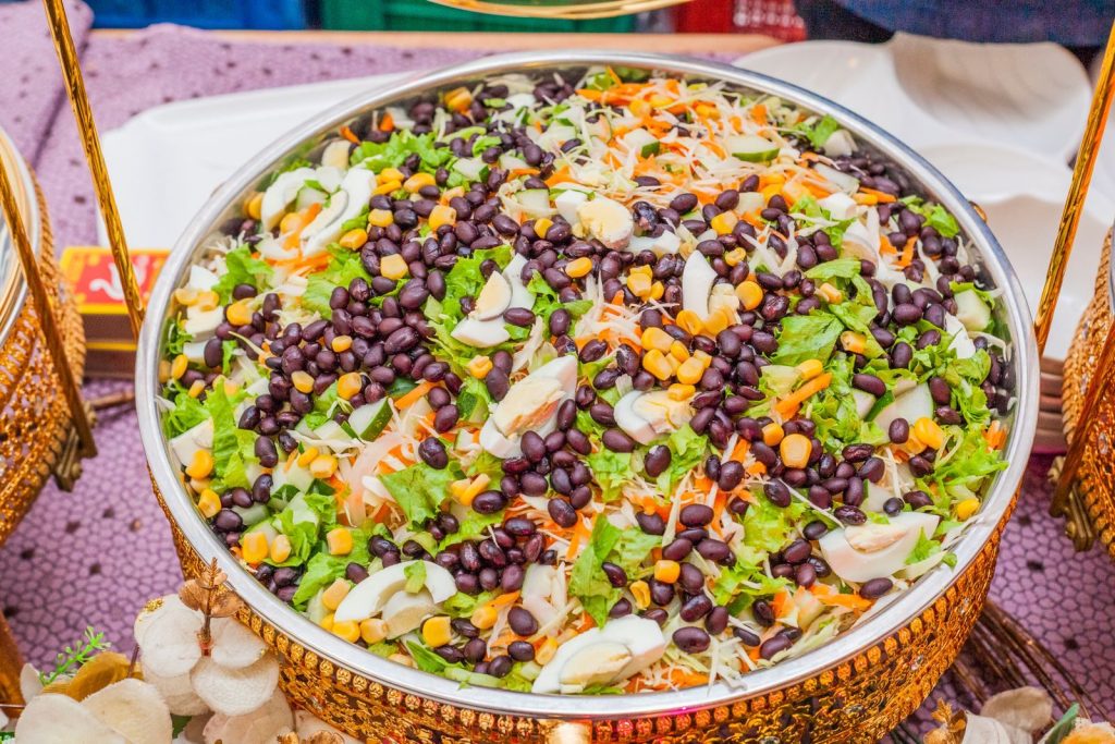 Colorful salad with black beans, corn, and cabbage mix in a decorative brass bowl.