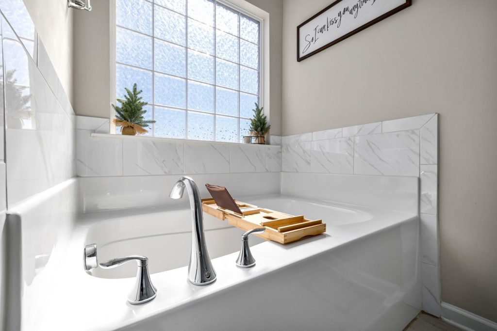 Minimalist bathroom design featuring a large bathtub with natural light from a window.