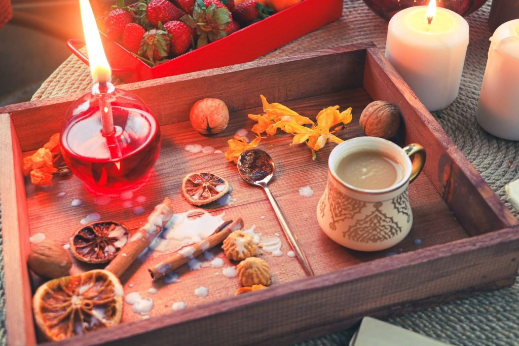 Warm autumn setting with coffee, candlelight, and seasonal decor on a tray.