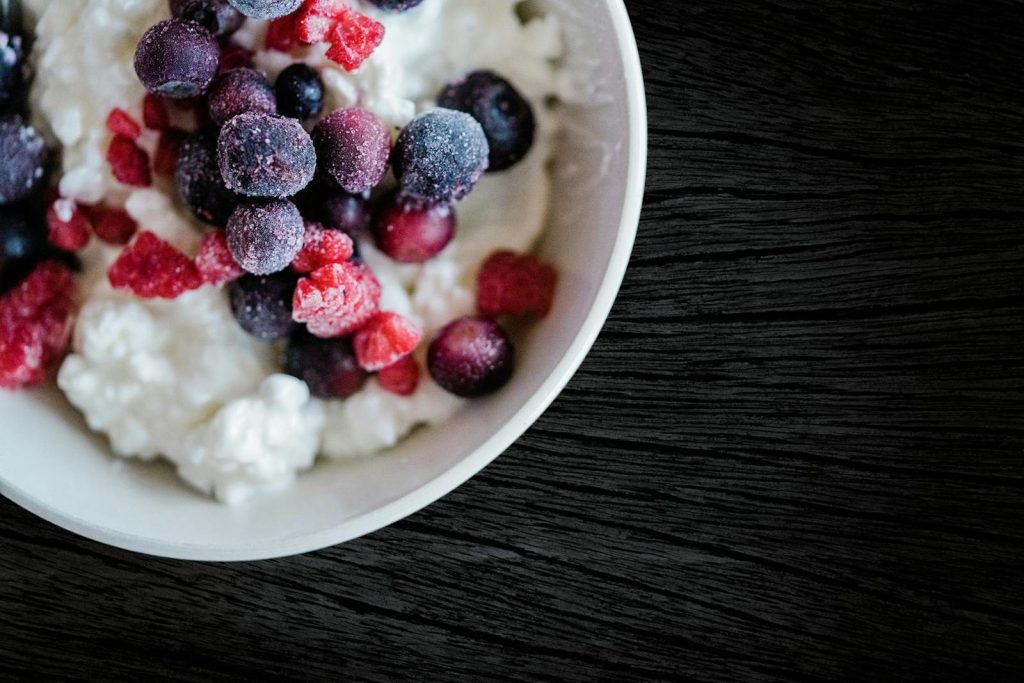 Delicious frozen berries atop creamy cottage cheese, perfect for a refreshing breakfast.