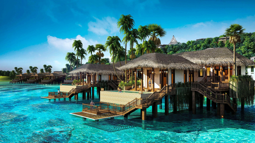 Scenic view of tropical overwater villas surrounded by clear blue water and palm trees in Vietnam.