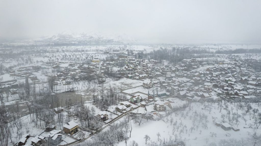 A stunning aerial view of a snow-covered town nestled in a winter landscape.