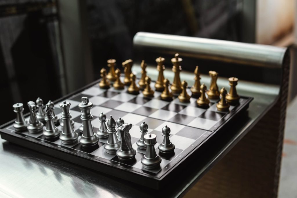 Elegant chessboard with gold and silver pieces, showcasing a polished modern design.