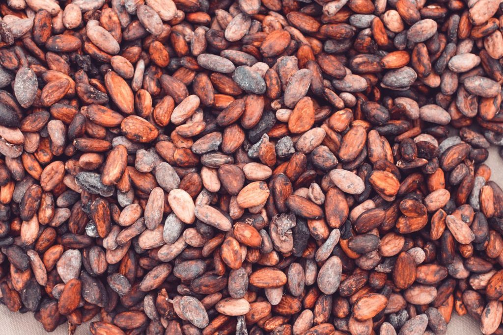 Close-up view of a large pile of fresh cocoa beans, ideal for chocolate production.