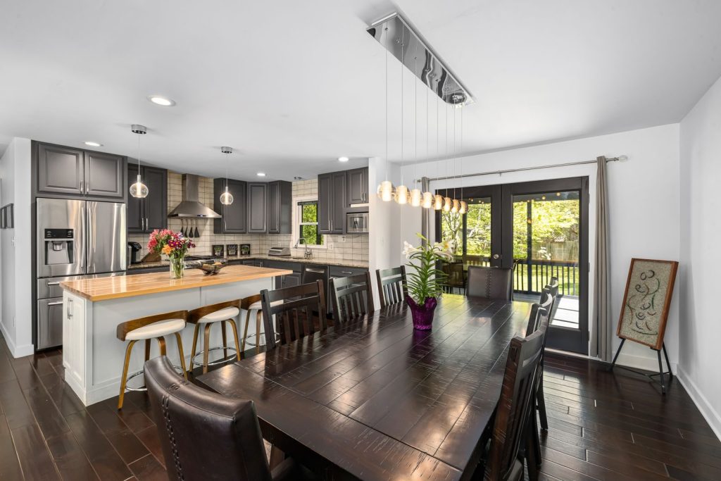 Spacious kitchen with dining room, modern decor, and natural light.
