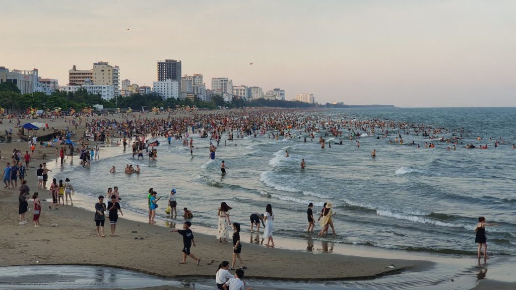 Crowded Sầm Sơn beach in Vietnam with people enjoying the summer by the sea.