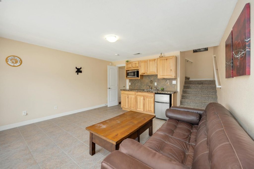 Spacious living room with kitchen and staircase. Ideal for a warm, inviting home environment.