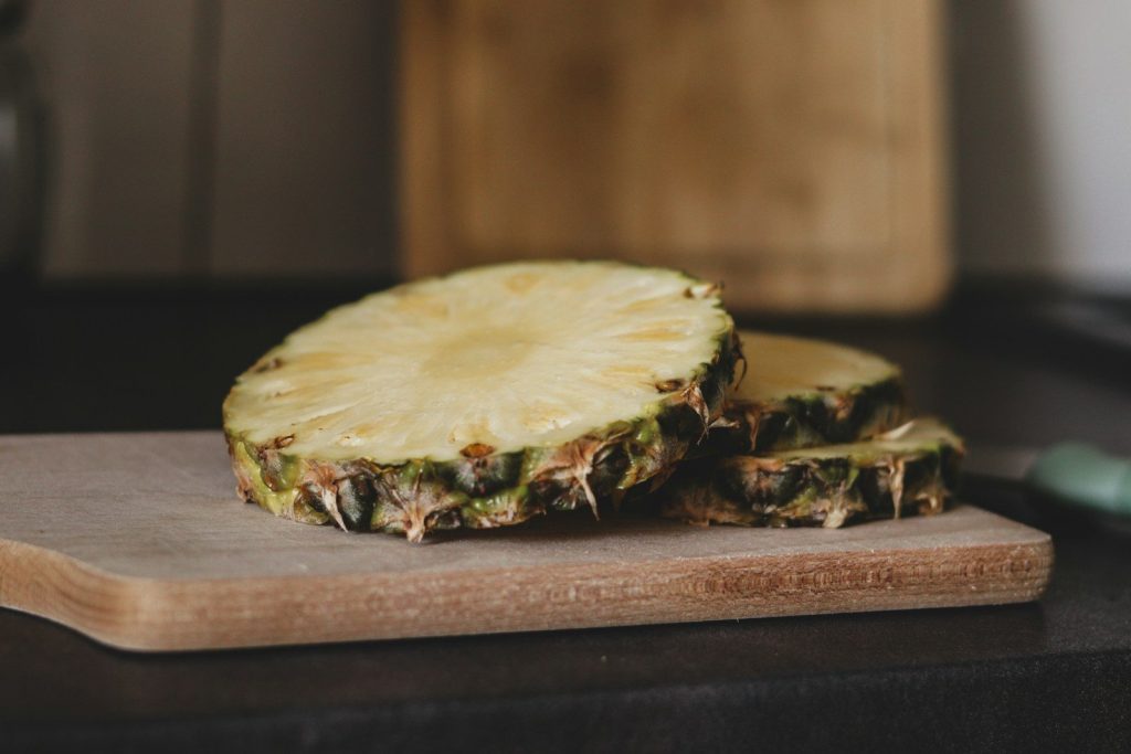 A pineapple sitting on top of a wooden cutting board
