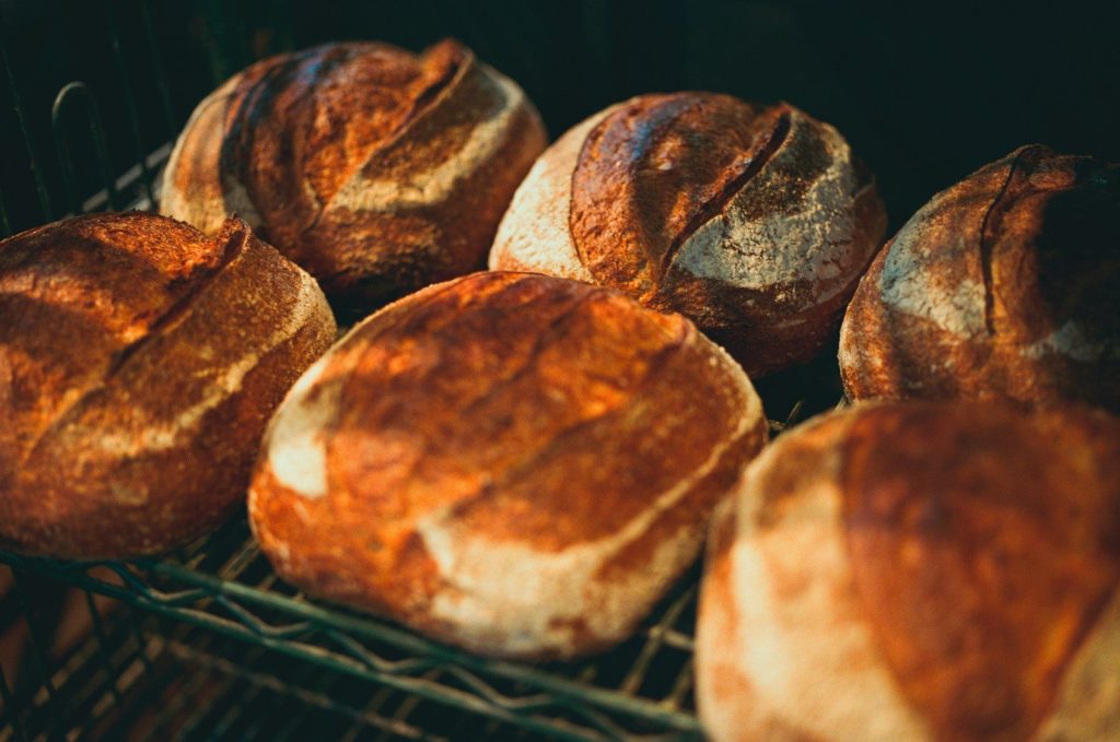 Several loaves of artisan bread on a rack.