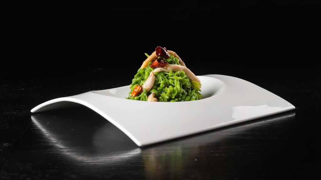 Close-up of a gourmet vegetable dish elegantly presented on a designer plate, perfect for fine dining settings.