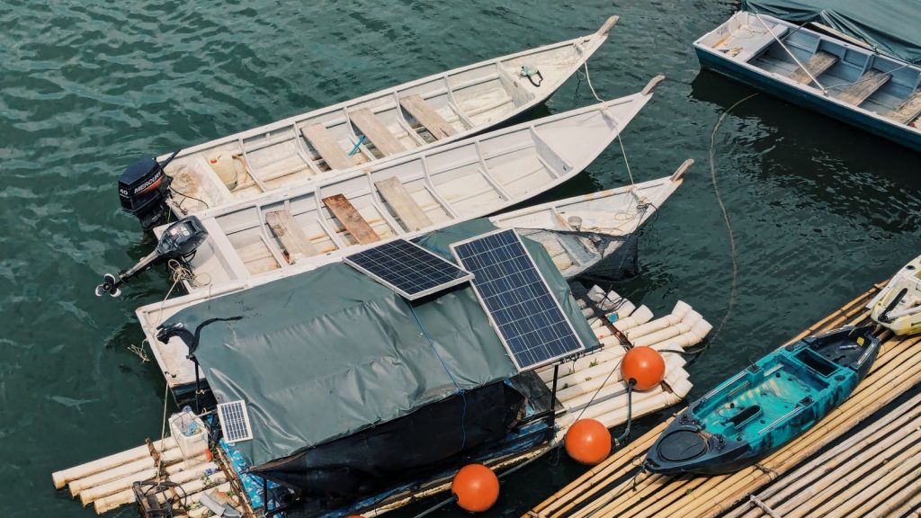 Aerial view of boats moored on a lake in Perak, Malaysia with solar panels.