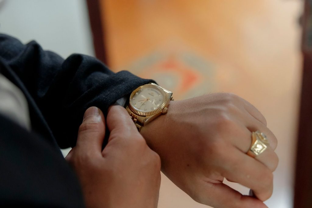 Close-up of a luxurious gold wristwatch on a person's wrist, highlighting elegance and style.