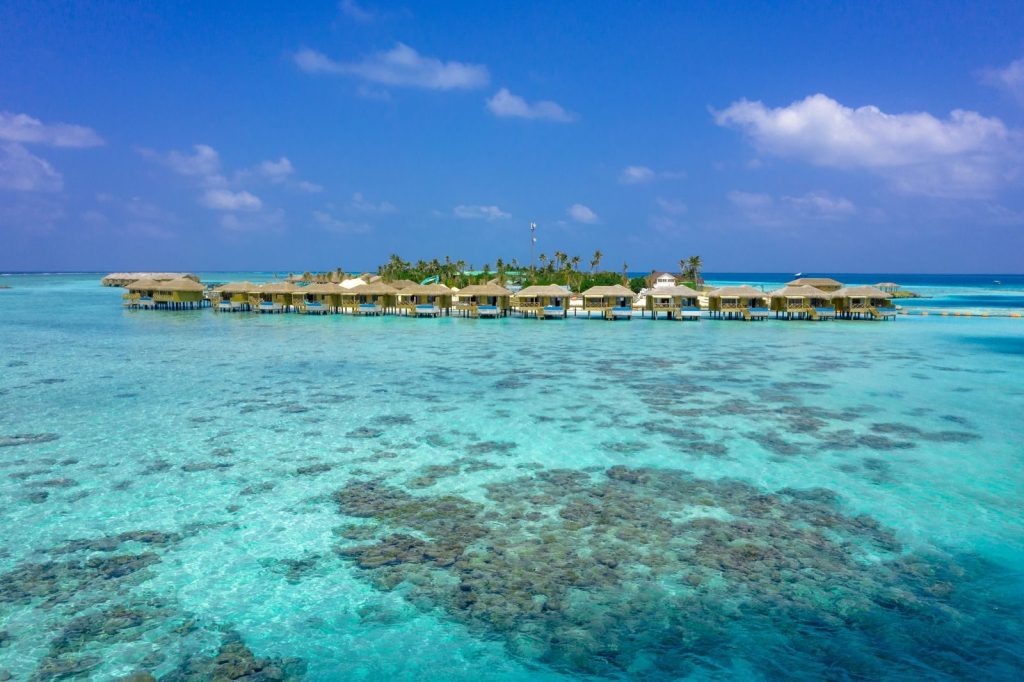 Aerial view of picturesque overwater bungalows in Maldives' turquoise waters.
