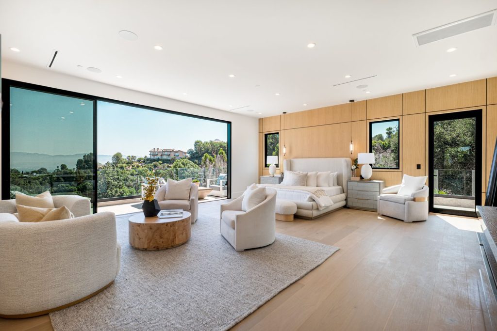Spacious modern bedroom featuring elegant furniture and a scenic view.