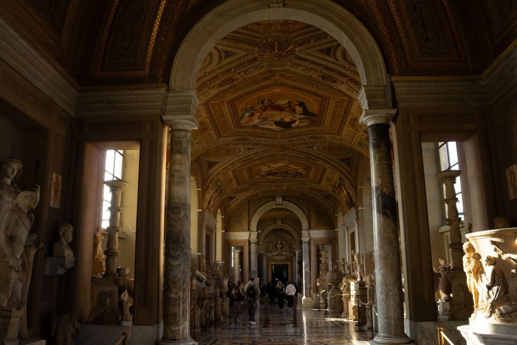 Grandiose hallway with sculptures in a historic museum, natural lighting.