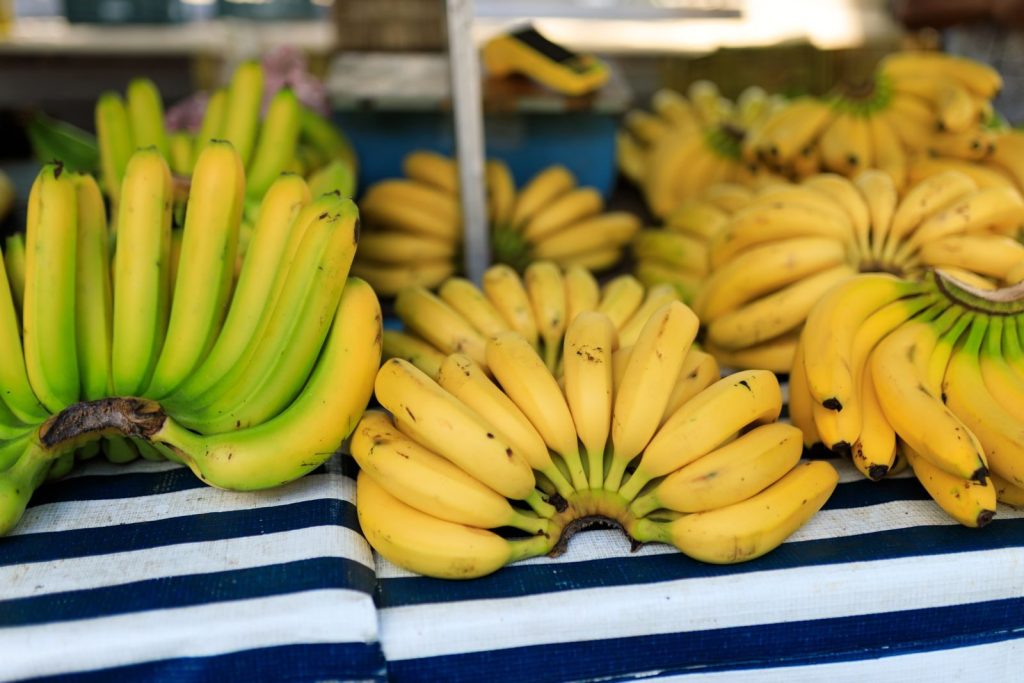 Close-up of ripe bananas arranged on a market stall, highlighting freshness.