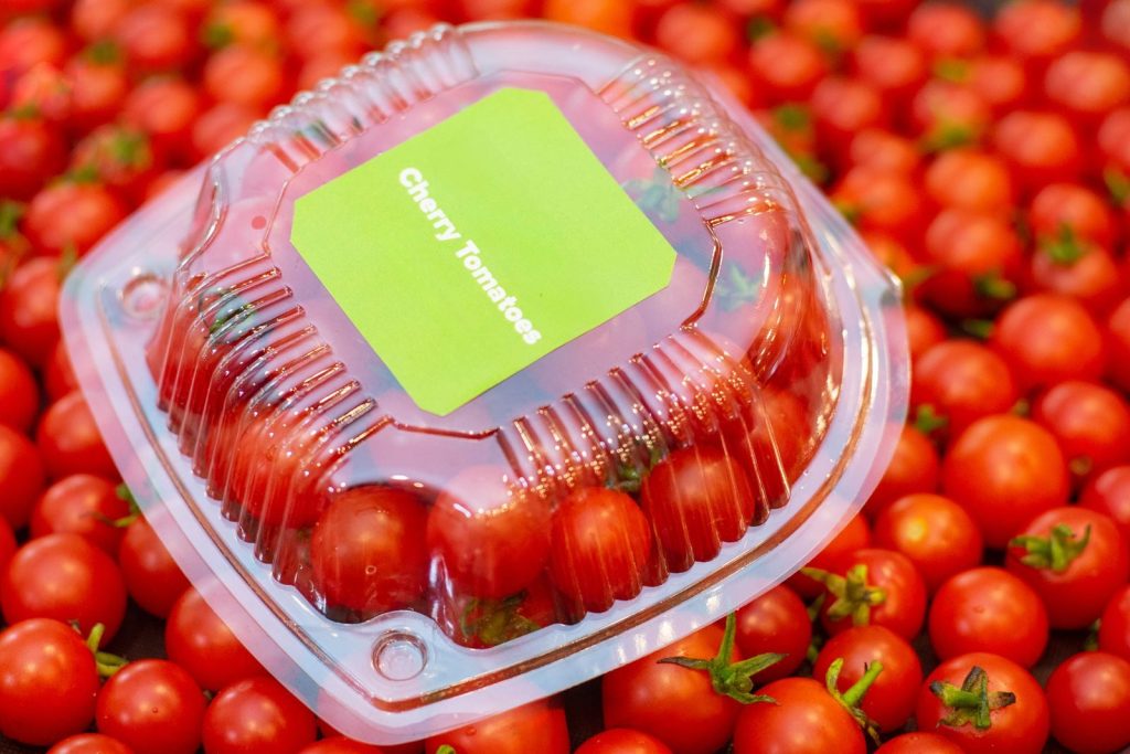 Bright cherry tomatoes in a clear plastic package, ideal for culinary and market visuals.