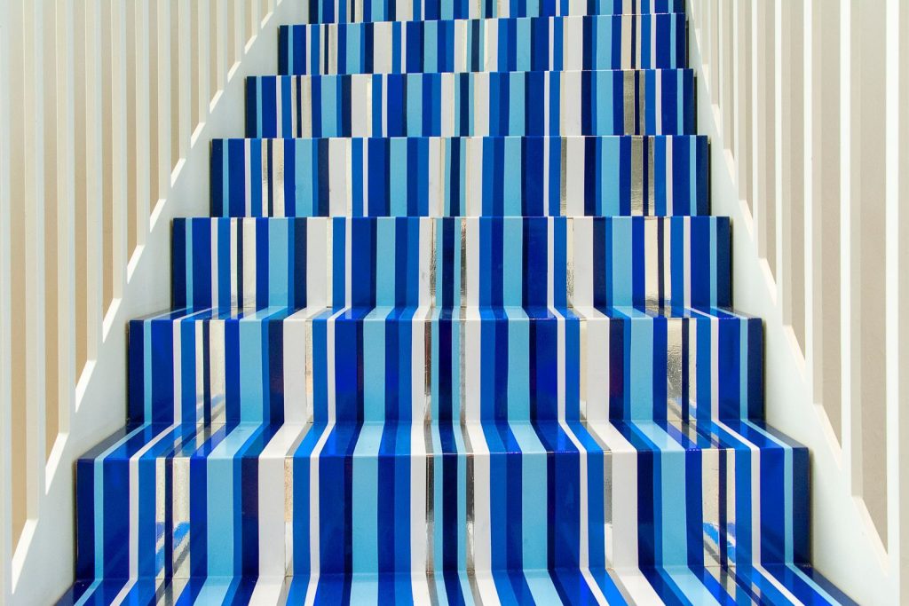 Bold blue and white striped staircase inside a bright modern setting.
