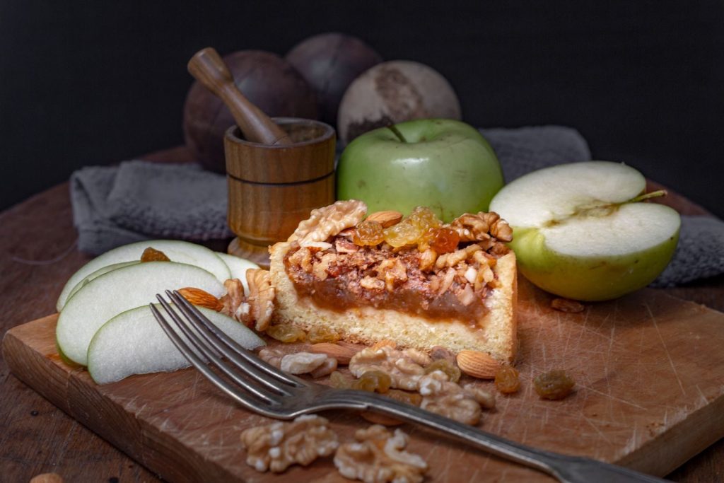 Close-up of a tasty apple nut cake with fresh green apples and walnuts.