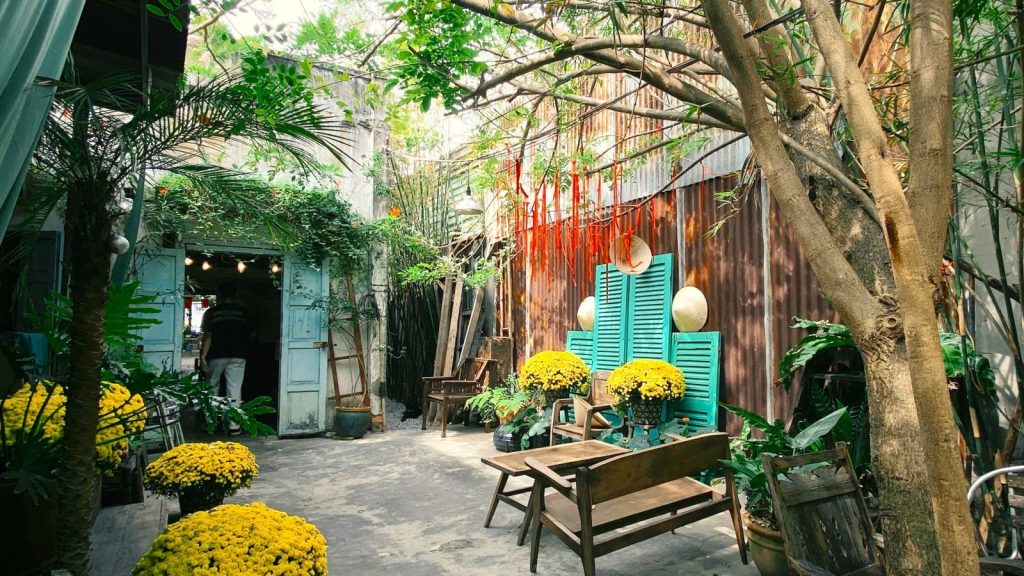 Serene outdoor courtyard with vibrant yellow flowers, rustic decor, and natural charm.