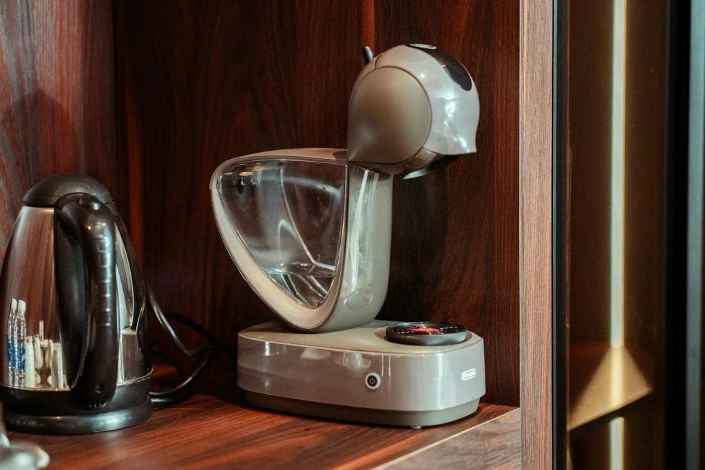 Stylish coffee machine and kettle in elegant wooden kitchen setting, ideal for home or office use.