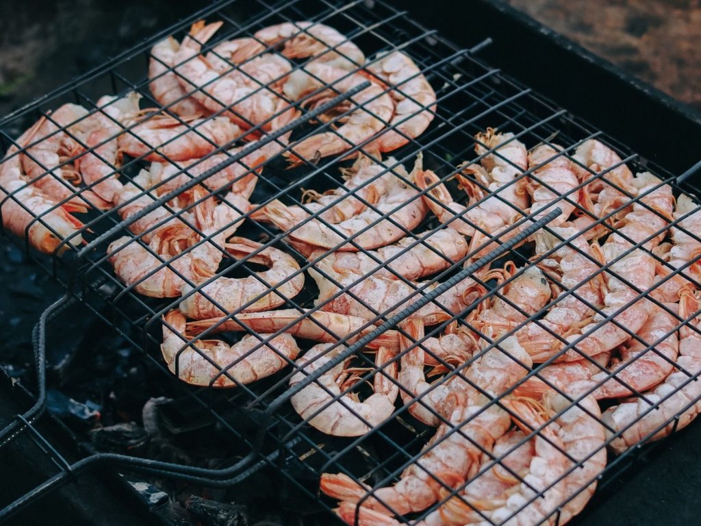 Tasty shrimp grilling on a barbecue grill outdoors, perfect for summer cookouts.
