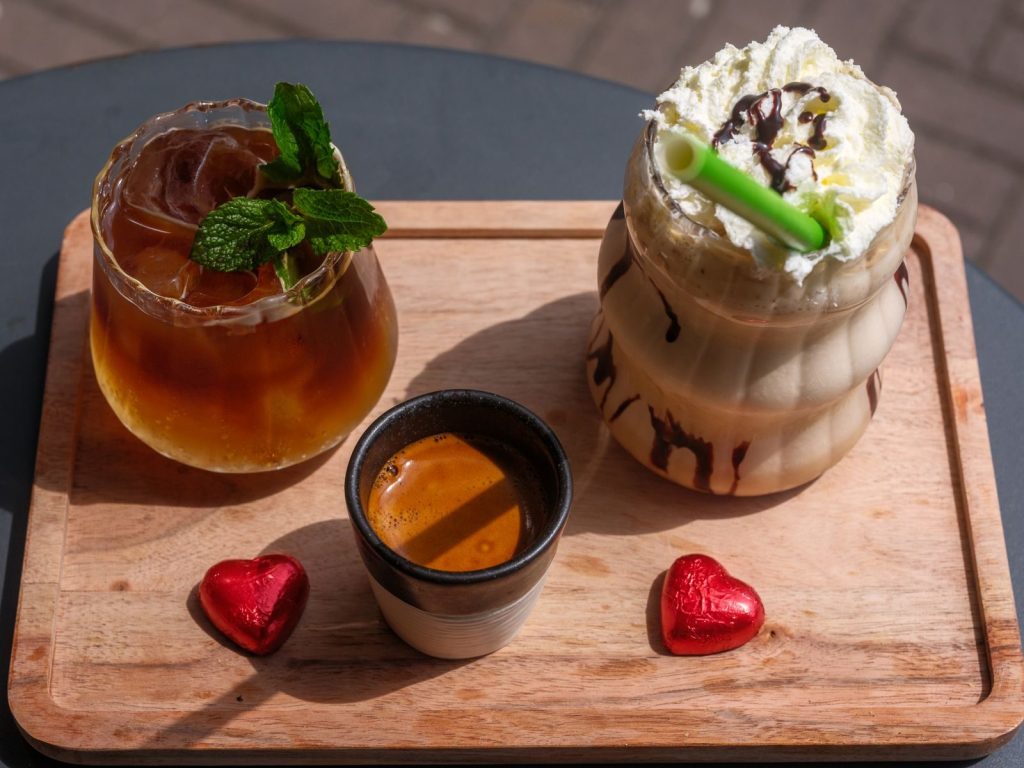 A vibrant display of iced drinks and espresso on a bamboo tray, perfect for café lovers.