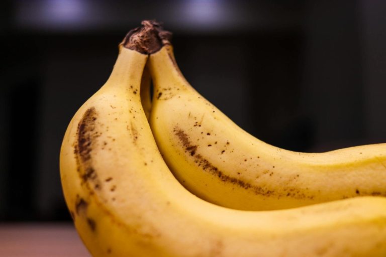 A close-up shot of two ripe bananas with a blurred background, highlighting texture and color.