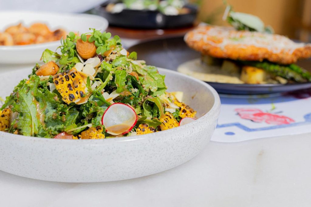 A delicious bowl of fresh salad with grilled corn and radish, perfect for a healthy meal.