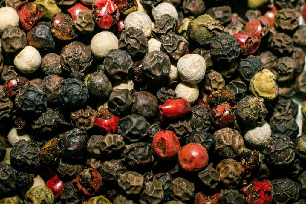 Vibrant close-up of various peppercorns showcasing texture and color variety.