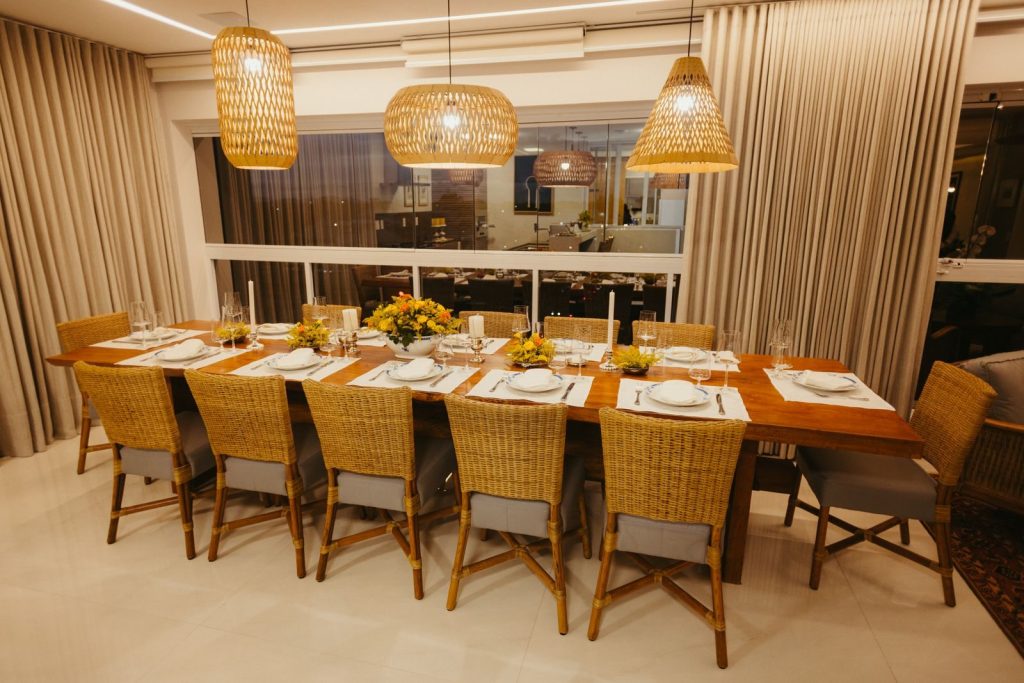 A beautifully arranged dining table with rattan chairs and floral centerpiece in a modern setting.