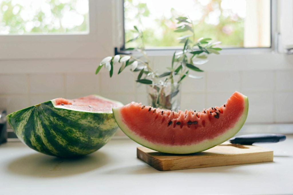 A juicy slice of watermelon on a cutting board indoors, perfect for enjoying summer freshness.