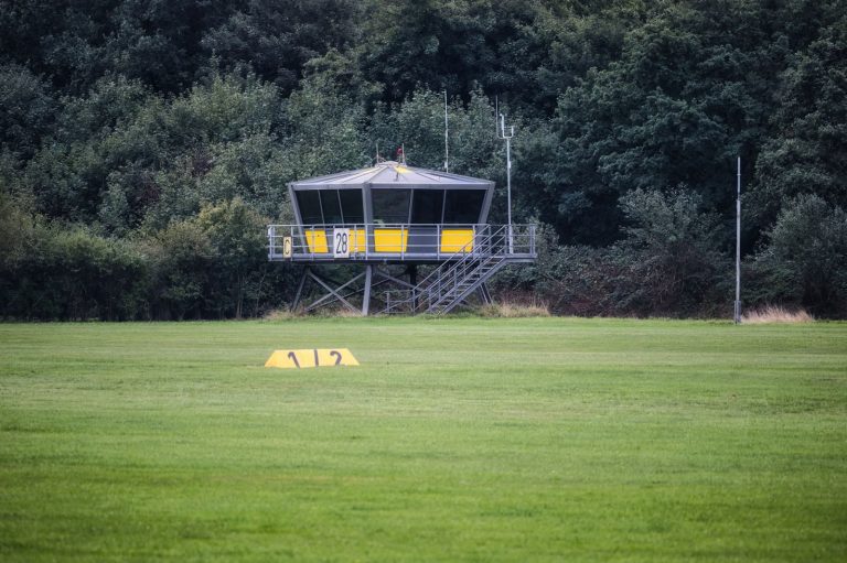 A rural airfield control tower surrounded by lush greenery, perfect for small aircraft coordination.