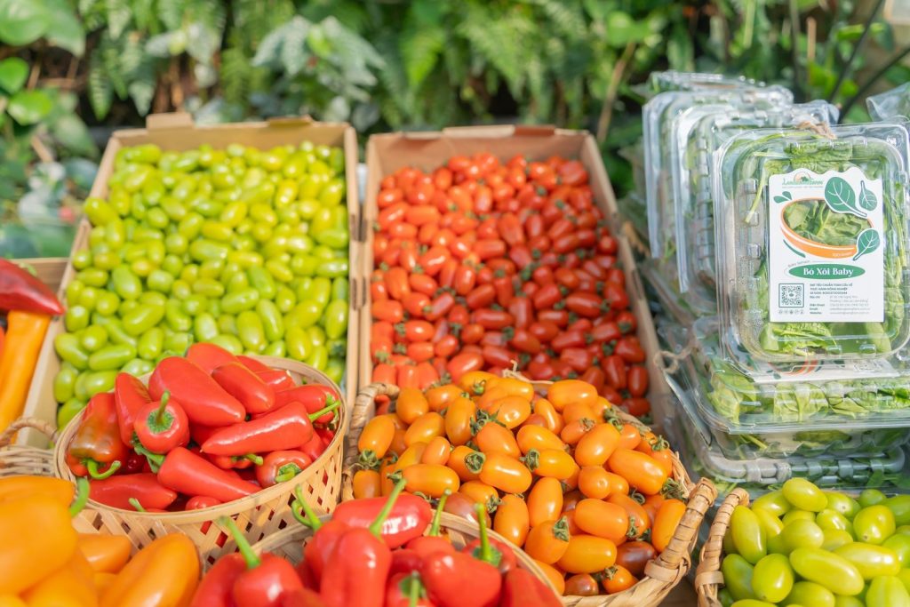 A vibrant assortment of fresh vegetables including peppers and tomatoes at a market.
