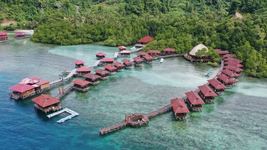 Scenic aerial view of overwater bungalows on a lush tropical island resort.