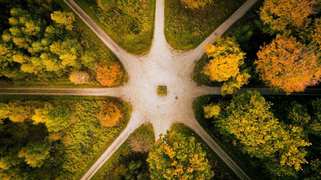 Unique aerial shot of a forest intersection with vibrant autumn foliage in full display.