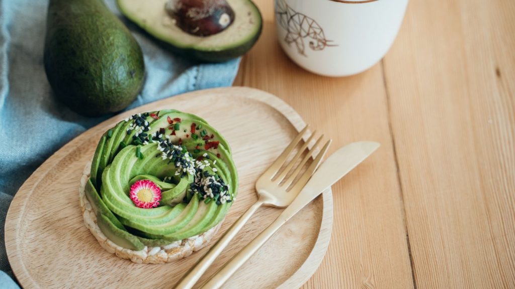 Artistic flatlay of vegan avocado toast with vibrant toppings, perfect for healthy breakfasts.