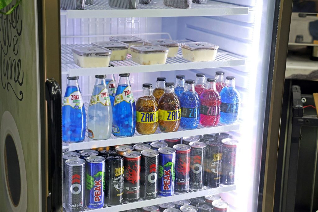 Refrigerated display case filled with drinks and desserts.